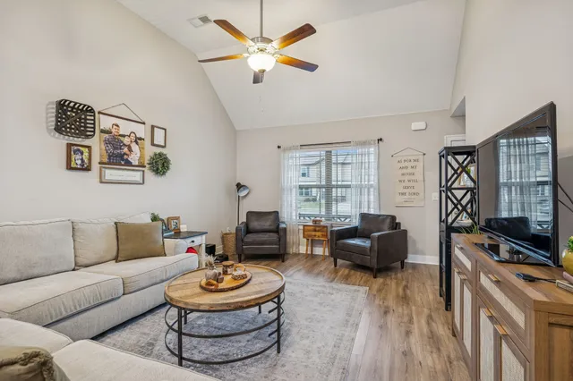 a living room with furniture a rug and a flat screen tv