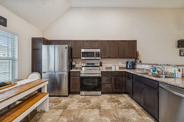 a kitchen with stainless steel appliances a stove a sink and a refrigerator