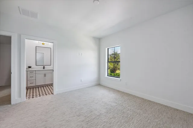 an empty room with windows and cabinet