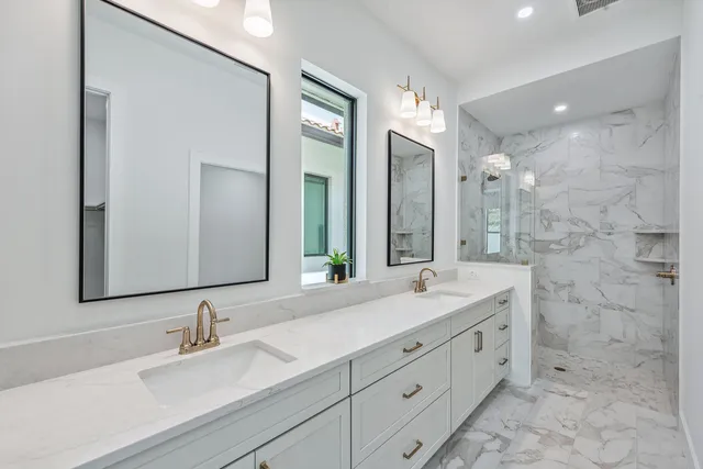 a bathroom with a double vanity sink mirror and shower