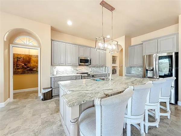a kitchen with stainless steel appliances kitchen island granite countertop a stove a sink and cabinets