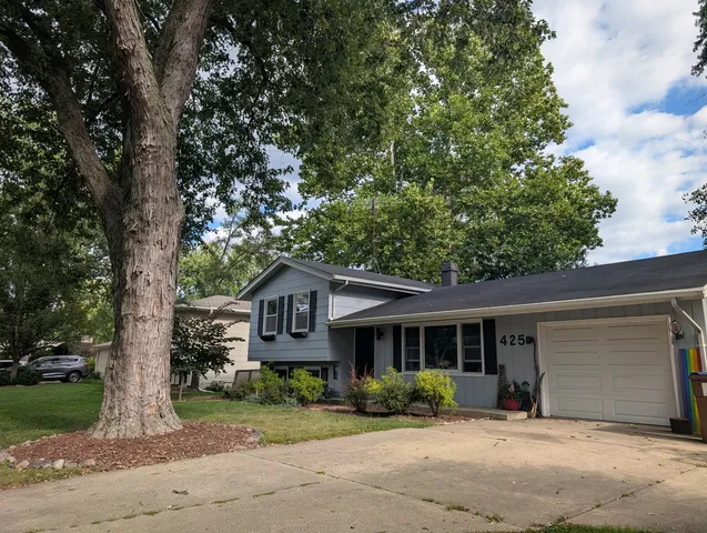 a front view of a house with a yard and potted plants