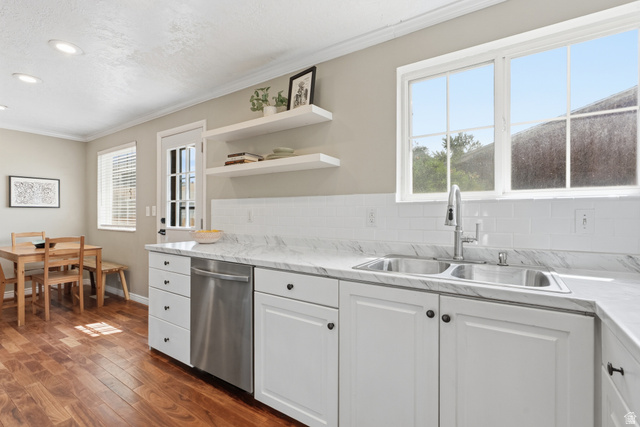 7795 South 1000 East Midvale, UT 84047 - Photo 9 of 42 Kitchen featuring white shaker-style cabinetry, stainless steel dishwasher, dual basin sink with gooseneck faucet, white subway tile backsplash, and wood-finish flooring