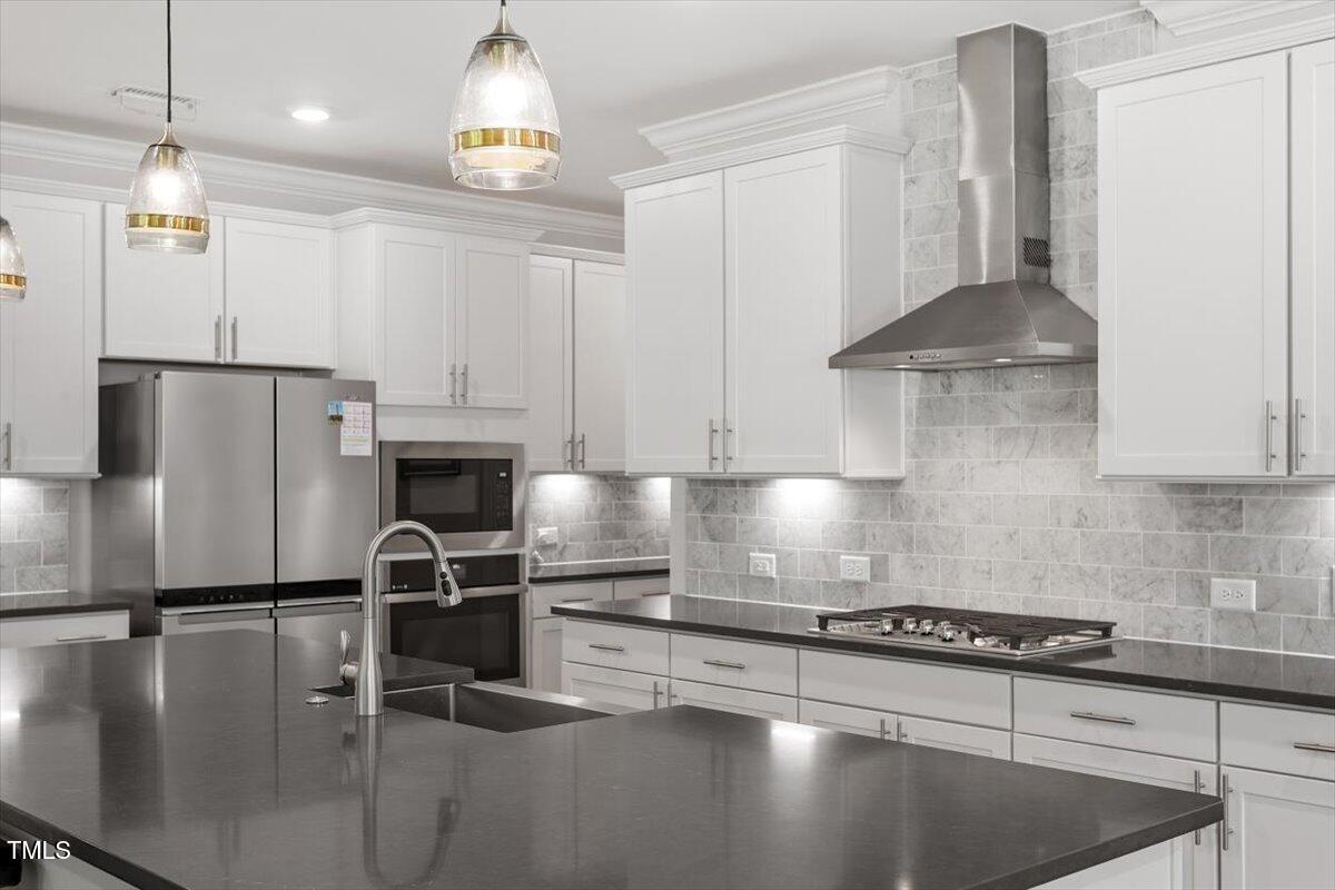 131 English Violet Lane Raleigh, NC 27610 - Photo 10 of 45 a kitchen with granite countertop a refrigerator a stove a sink a counter space and cabinets