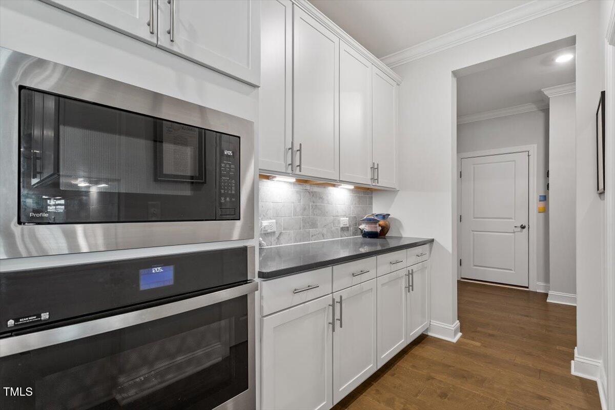 131 English Violet Lane Raleigh, NC 27610 - Photo 11 of 45 a kitchen with stainless steel appliances a stove a microwave and cabinets