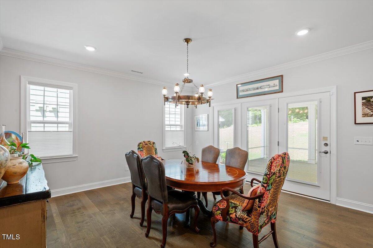 131 English Violet Lane Raleigh, NC 27610 - Photo 16 of 45 a dining room with furniture potted plants and wooden floor