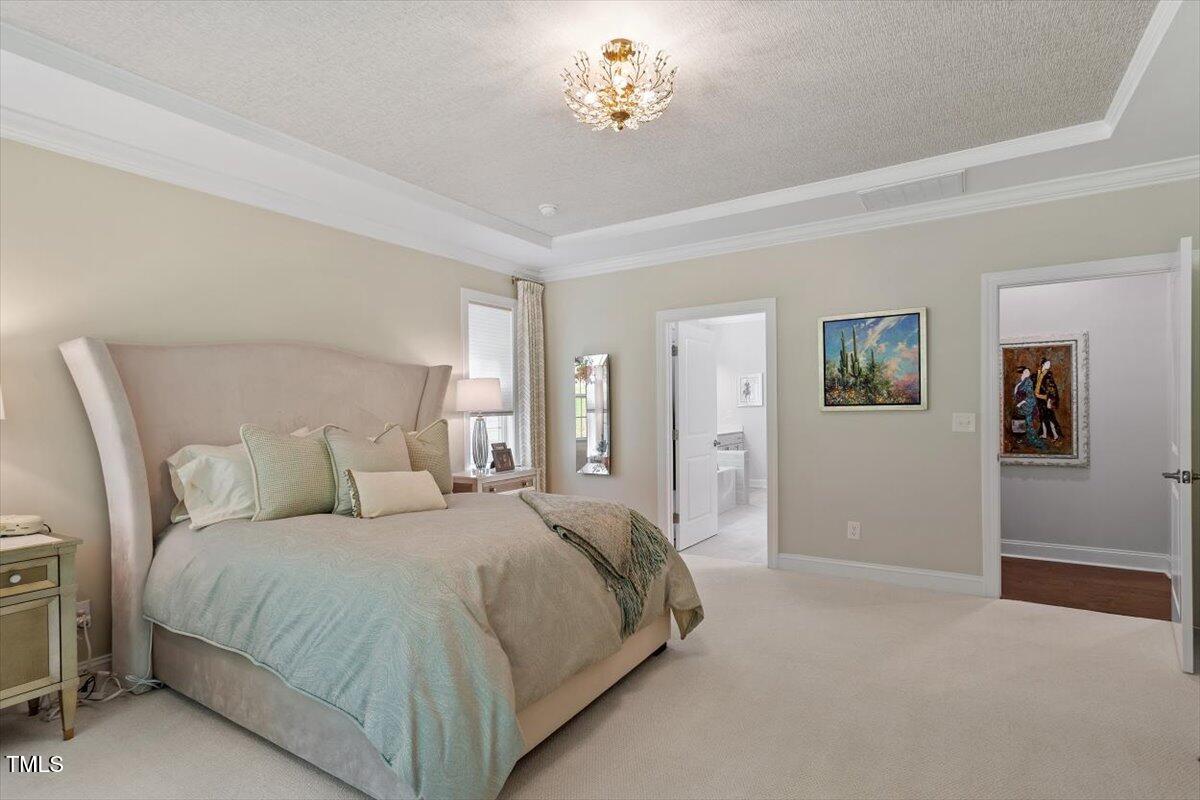 131 English Violet Lane Raleigh, NC 27610 - Photo 20 of 45 a bed room with a bed and a chandelier