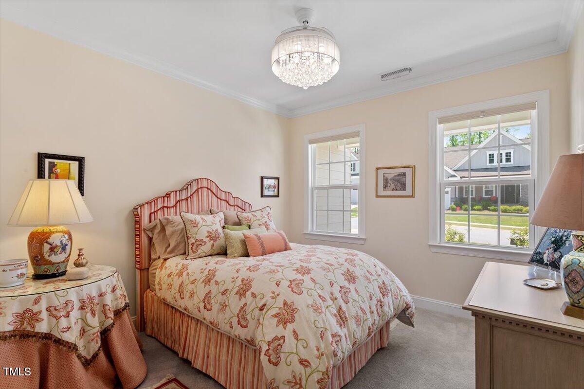 131 English Violet Lane Raleigh, NC 27610 - Photo 30 of 45 a bedroom with a bed and a table in it with window