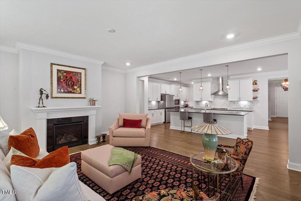 131 English Violet Lane Raleigh, NC 27610 - Photo 8 of 45 a living room with furniture a fireplace and kitchen view