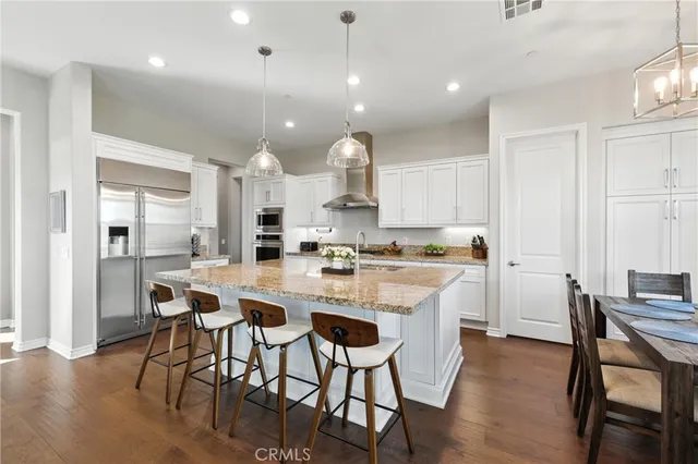 a large kitchen with kitchen island a dining table and chairs