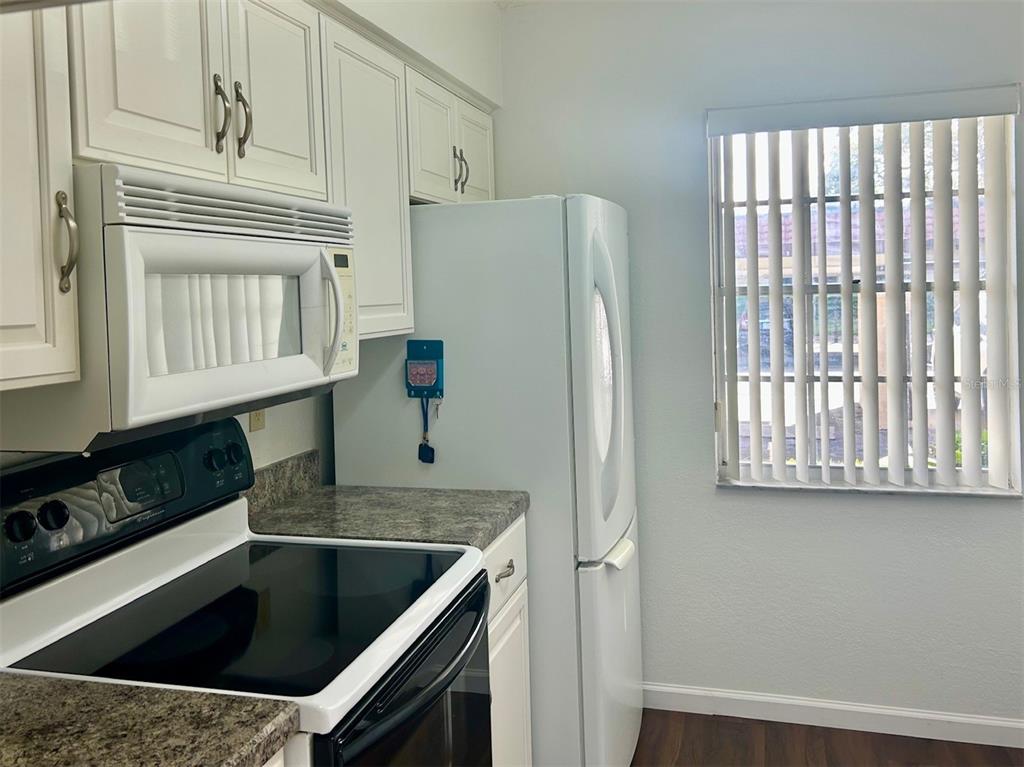 1701 Pinehurst Road, Unit 18C Dunedin, FL 34698 - Photo 3 of 17 a kitchen with granite countertop a sink a stove and refrigerator