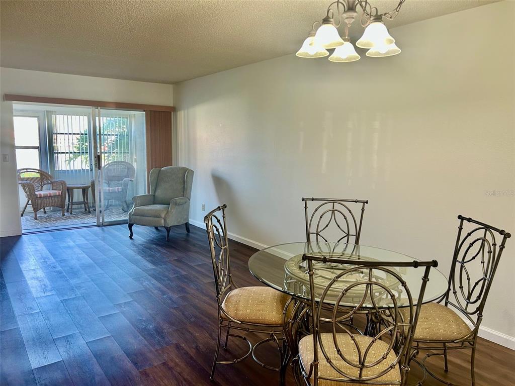 1701 Pinehurst Road, Unit 18C Dunedin, FL 34698 - Photo 6 of 17 a view of a dining room with furniture wooden floor and chandelier