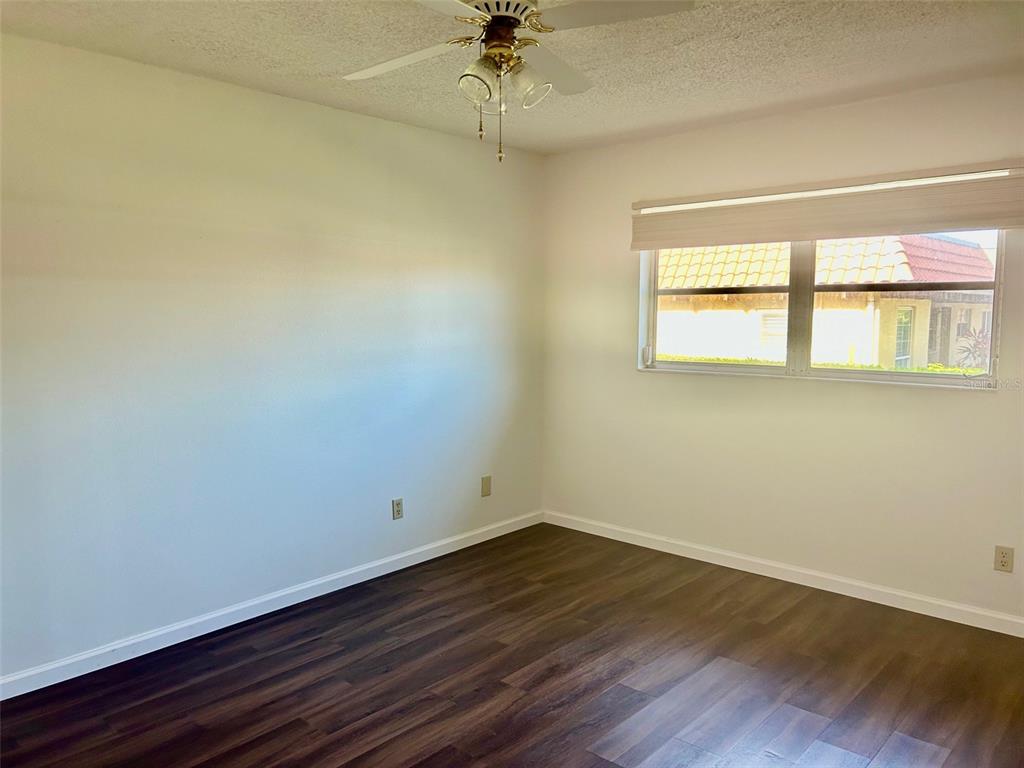 1701 Pinehurst Road, Unit 18C Dunedin, FL 34698 - Photo 8 of 17 an empty room with a window and wooden floor