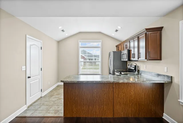 a kitchen with kitchen island granite countertop a sink window and cabinets