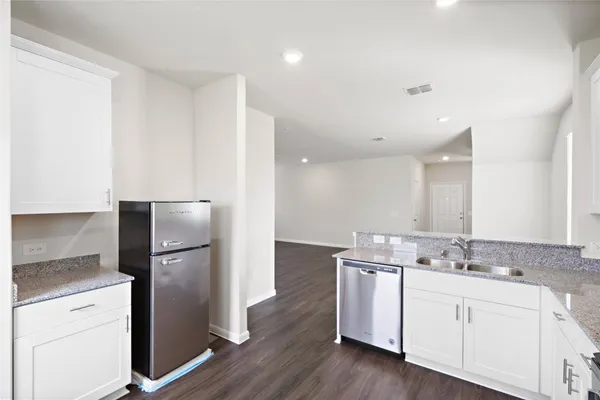 a kitchen with a refrigerator sink and cabinets