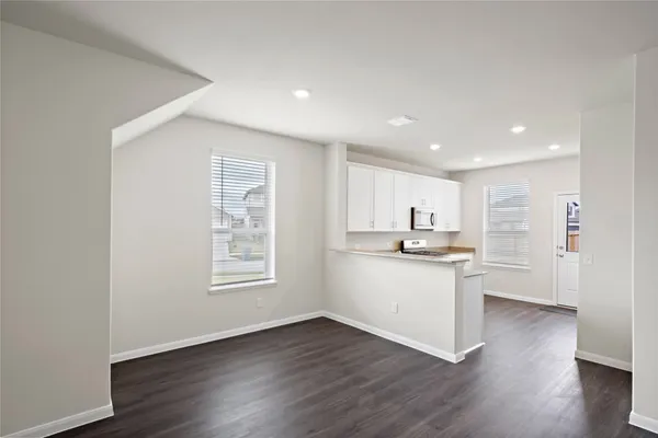 a kitchen with granite countertop a sink cabinets and wooden floor