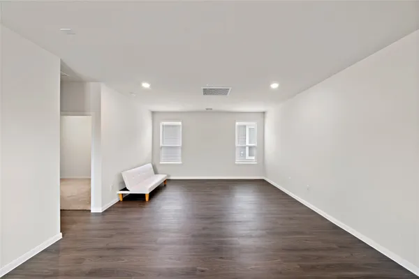 a view of empty room with wooden floor and window