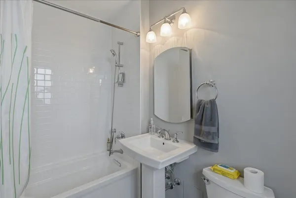 a bathroom with a sink a light fixture and a mirror