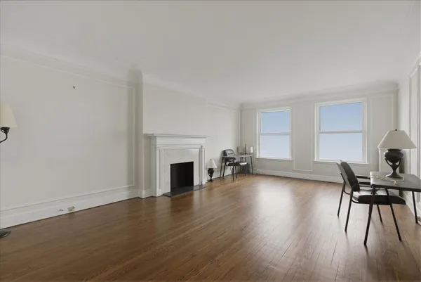 a view of empty room with fireplace and wooden floor