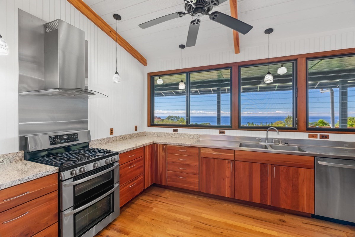 1613 Puu Road, Unit B Kalaheo, HI 96741 - Photo 6 of 27 a kitchen with stainless steel appliances granite countertop a sink and wooden cabinets