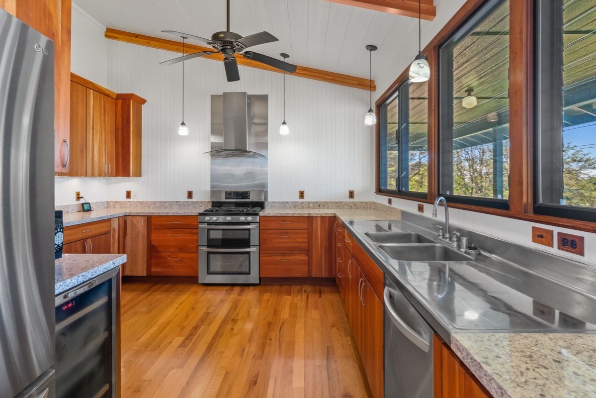 1613 Puu Road, Unit B Kalaheo, HI 96741 - Photo 7 of 27 a kitchen with stainless steel appliances granite countertop a sink a stove and a wooden floors