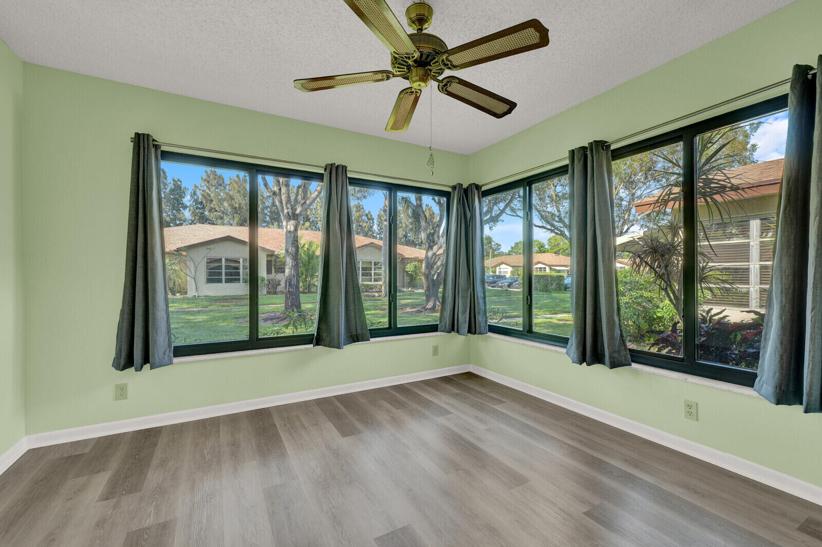 5270 Nesting Way, Unit C Delray Beach, FL 33484 - Photo 19 of 38 a view of an empty room with a window and wooden floor
