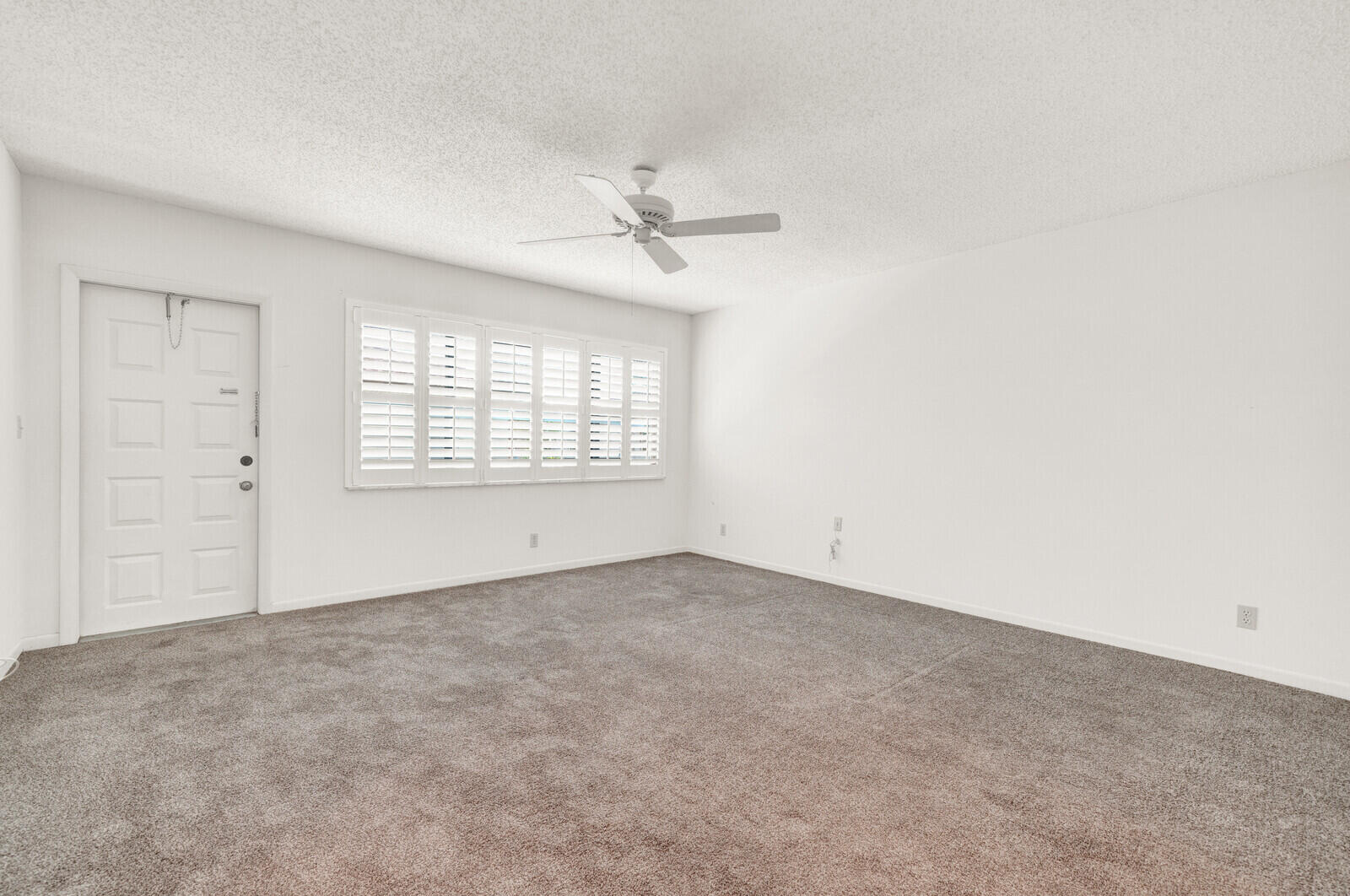 5270 Nesting Way, Unit C Delray Beach, FL 33484 - Photo 23 of 38 an empty room with windows and ceiling fan