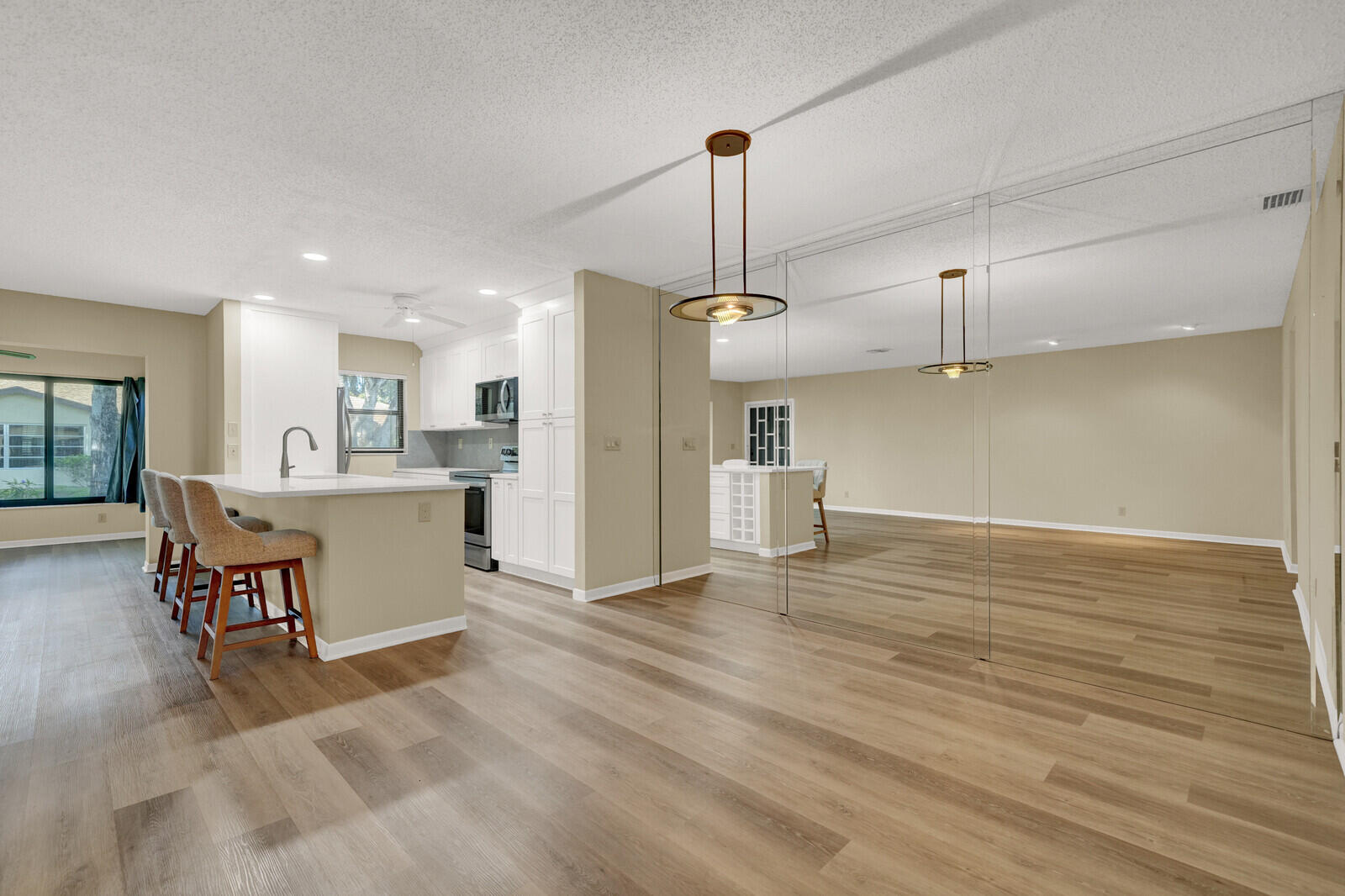 5270 Nesting Way, Unit C Delray Beach, FL 33484 - Photo 7 of 38 a view of kitchen with refrigerator stove and a dining table with wooden floor