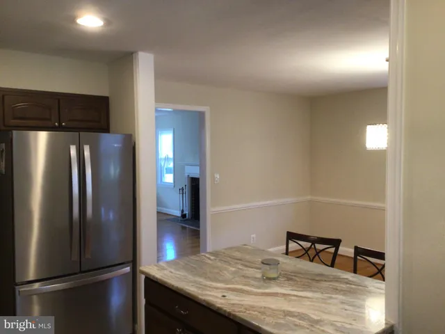 a kitchen with metallic refrigerator and table