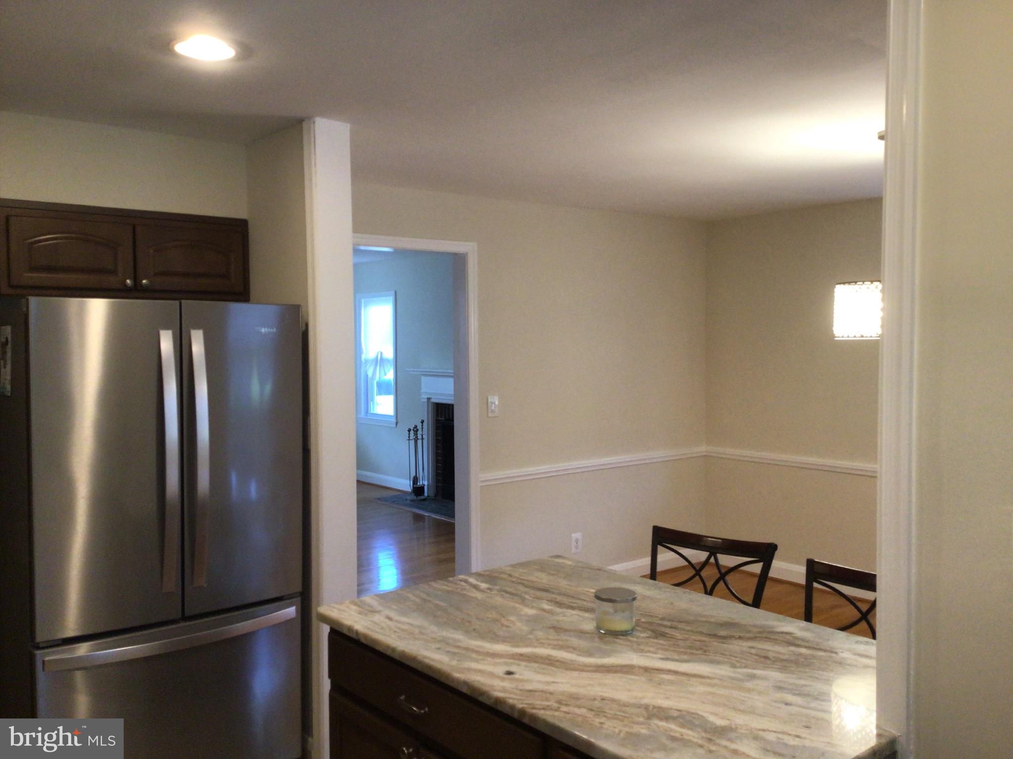 1613 Winford Road Baltimore, MD 21239 - Photo 17 of 42 a kitchen with metallic refrigerator and table