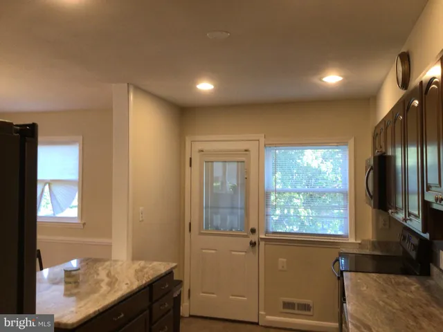 a view of hallway with a large window and wooden floor