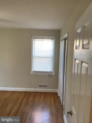 a view of a room with wooden floor and a window