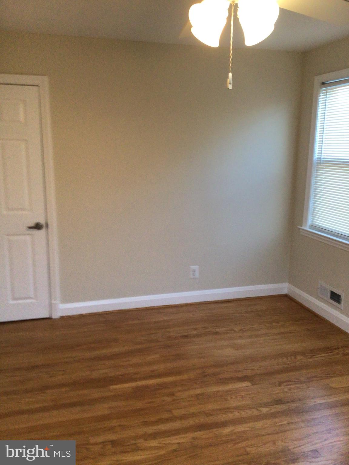 1613 Winford Road Baltimore, MD 21239 - Photo 31 of 42 a view of an empty room with wooden floor and a window