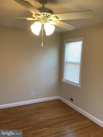 a view of a room with wooden floor and a window