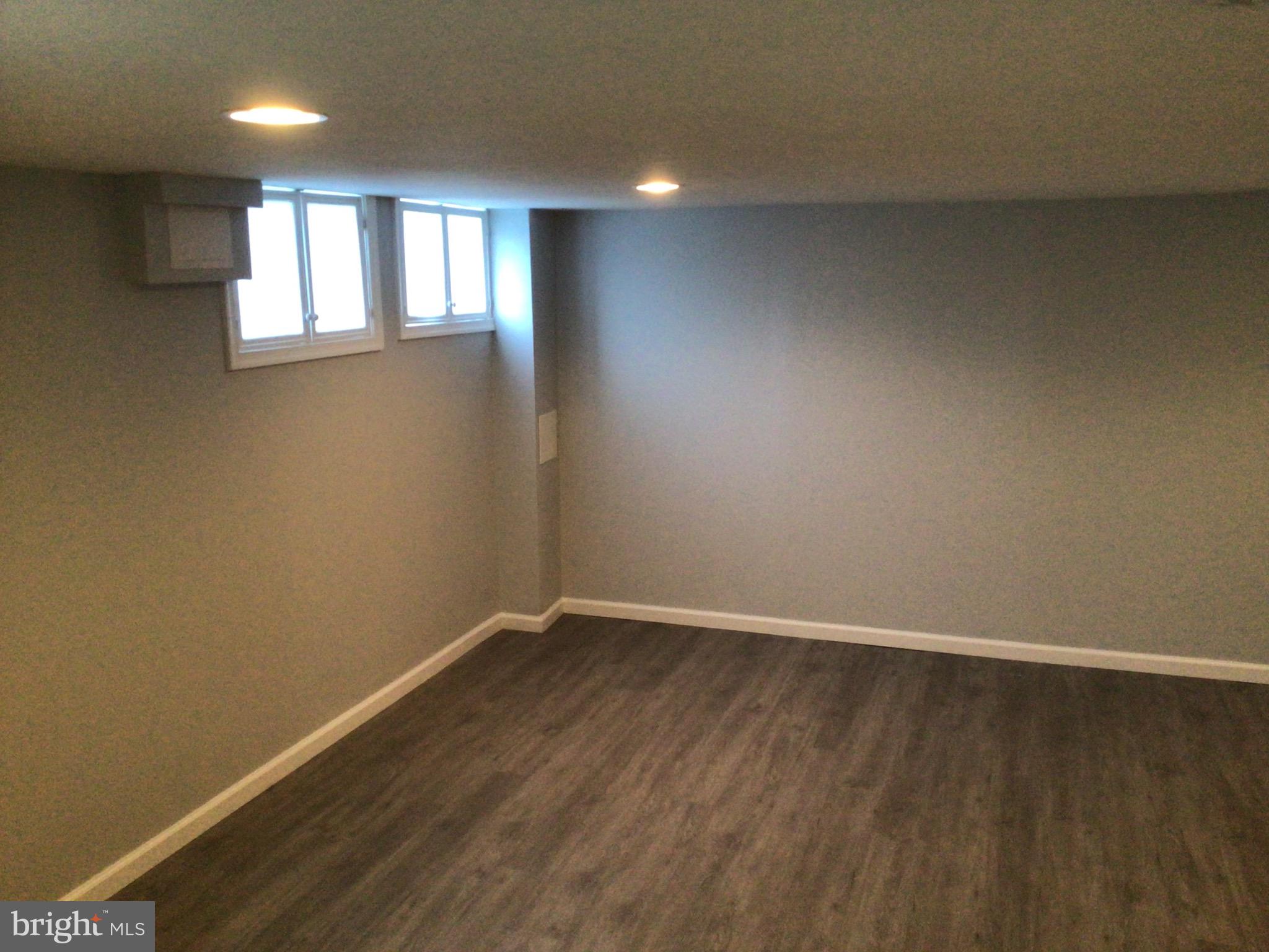 1613 Winford Road Baltimore, MD 21239 - Photo 38 of 42 an empty room with wooden floor and windows