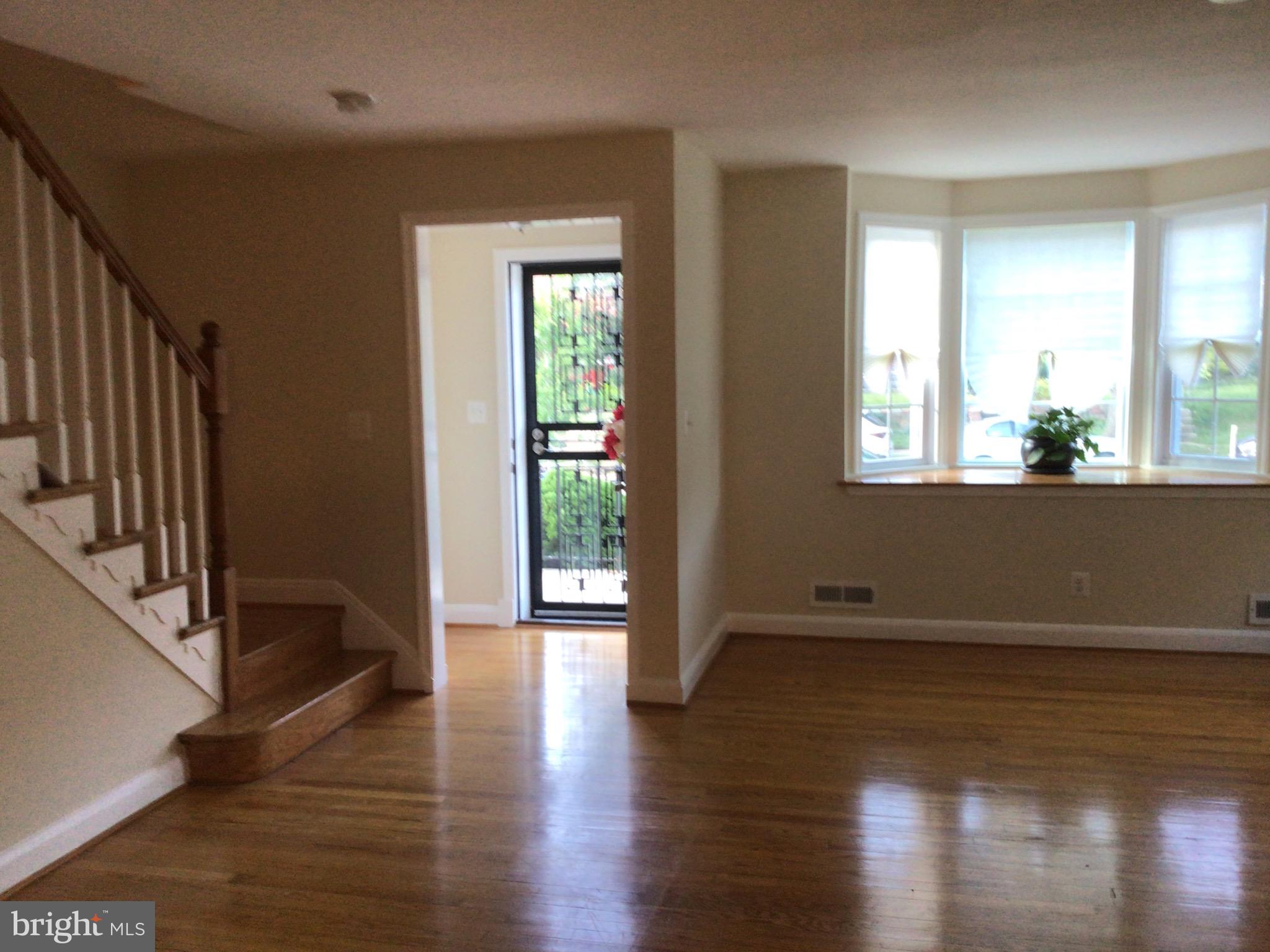1613 Winford Road Baltimore, MD 21239 - Photo 6 of 42 a view of an empty room with wooden floor and a window