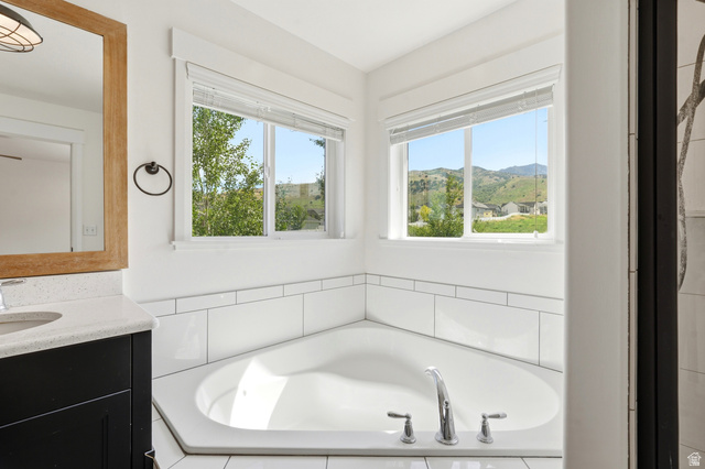 338 Windy Rdg Drive Smithfield, UT 84335 - Photo 34 of 63 Corner soaking tub with chrome fixtures, surrounded by white subway tile