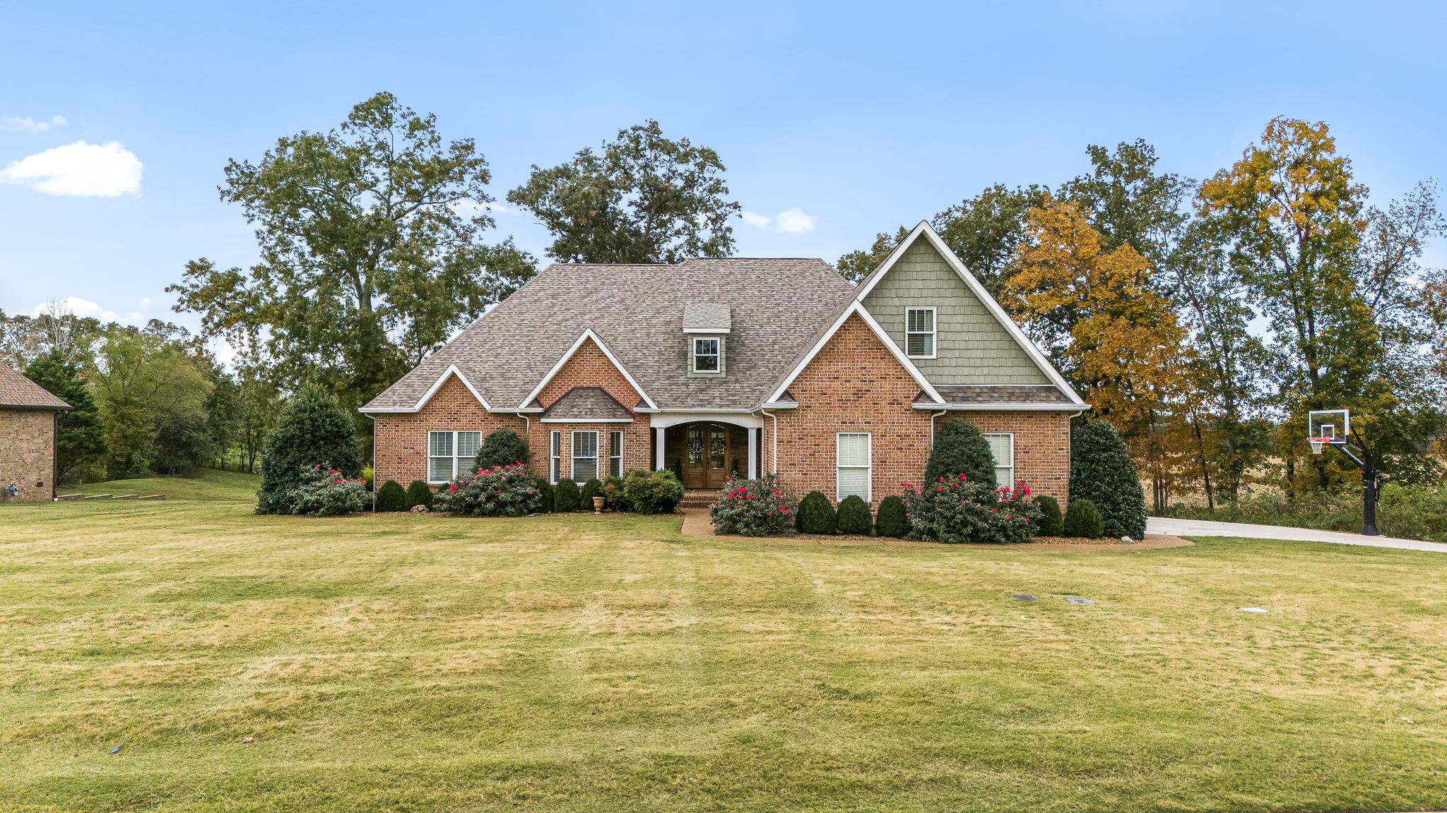 a front view of house with yard and trees in the background