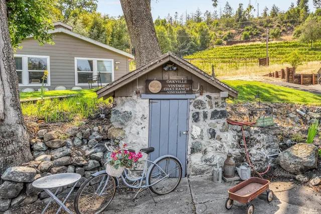 a view of a chair and table in backyard of the house