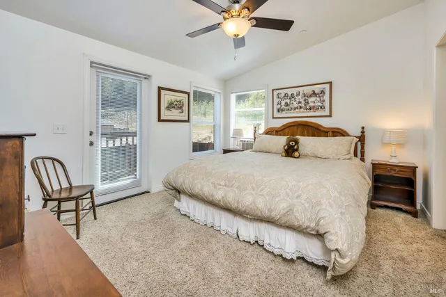 a bedroom with a bed furniture and two large window