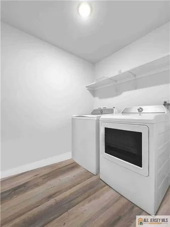 a view of an empty room with wooden floor and fireplace