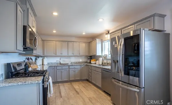 a kitchen with stainless steel appliances granite countertop a refrigerator and a stove top oven
