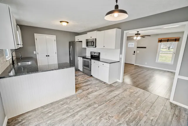 a kitchen with stainless steel appliances granite countertop a sink stove and refrigerator