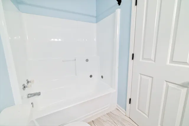 an empty room with a window and a chandelier fan