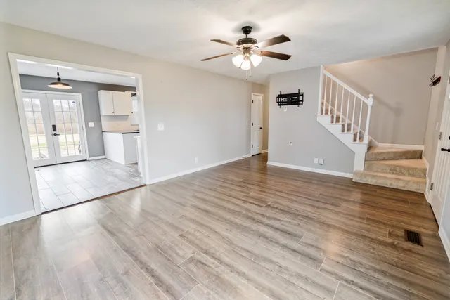 a large white kitchen with granite countertop wooden cabinets a stove a sink and a large window