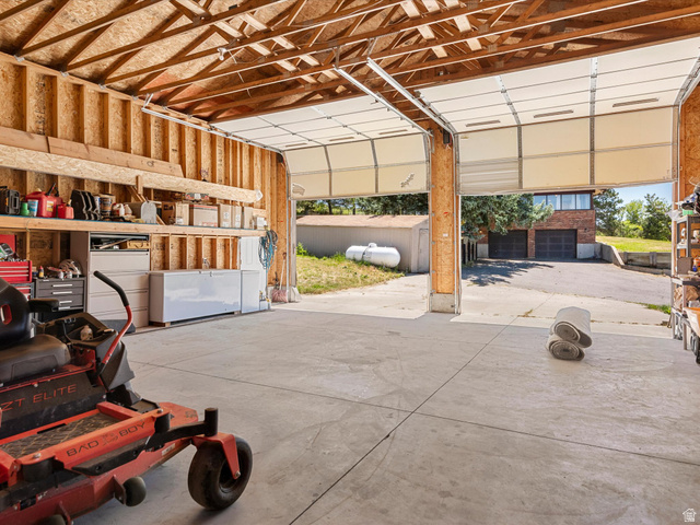 15680 North Beaver Dam Road Collinston, UT 84306 - Photo 39 of 49 Spacious two-bay garage with overhead doors, exposed wood framing, and concrete flooring