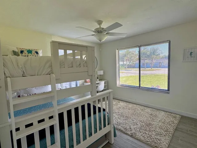 a bedroom with a bed window and a chandelier