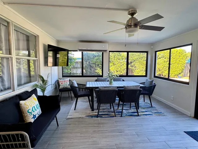 a view of a patio with couches and a table and chairs with wooden floor