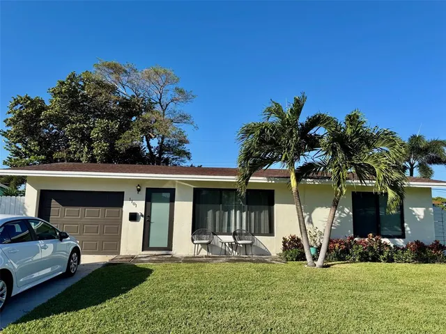 a view of a house with a yard and sitting area