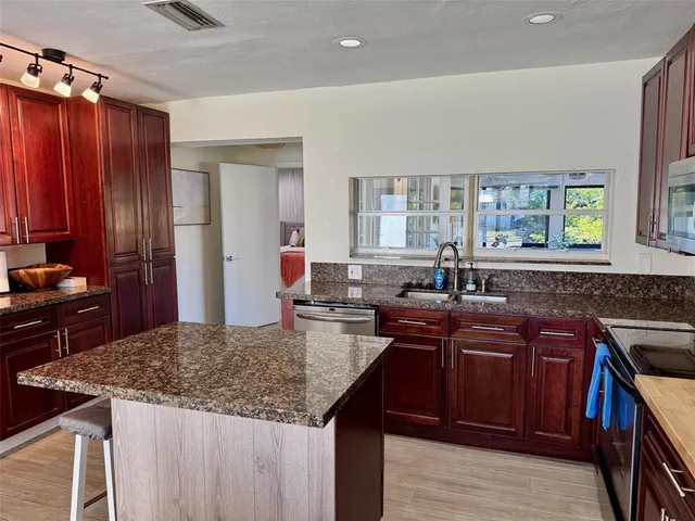 a kitchen with granite countertop lots of counter top space and appliances